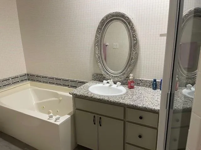 a bathroom with a granite countertop sink a mirror and a mirror