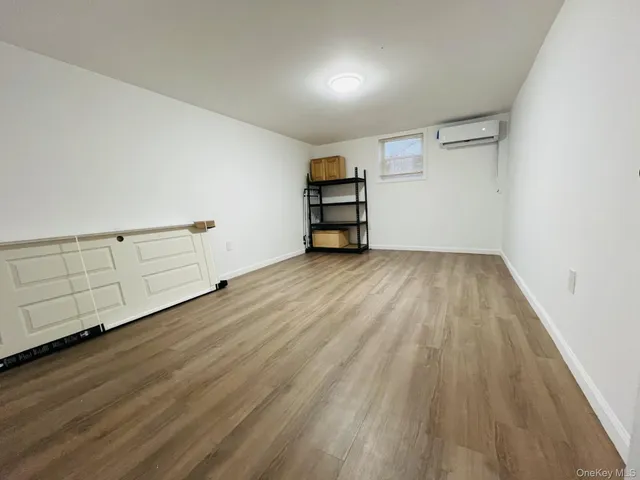 an empty room with wooden floor closet and windows