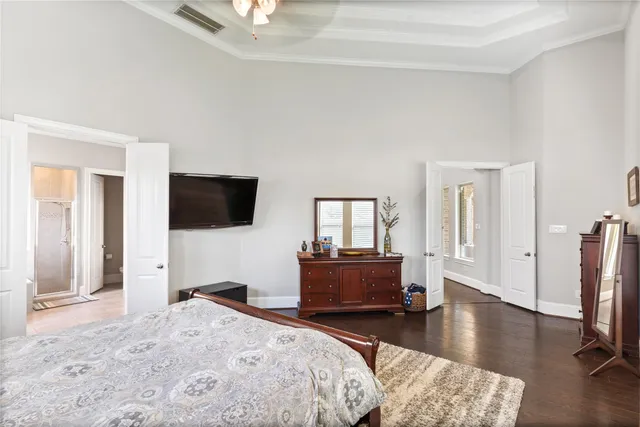 a bedroom with a bed and a flat tv screen on wall