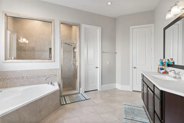 a spacious bathroom with a tub shower and sink