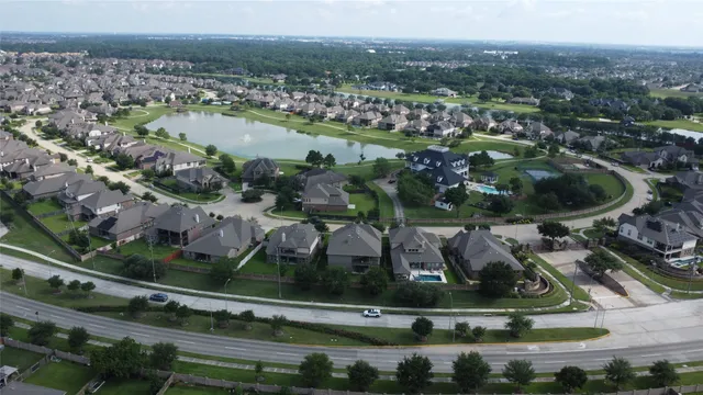 an aerial view of residential houses with outdoor space and swimming pool