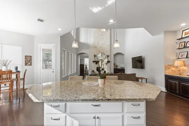 a large kitchen with granite countertop a large counter top appliances and cabinets