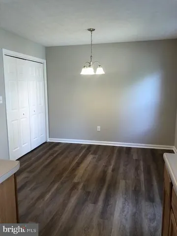 a view of a room with wooden floor and a ceiling fan
