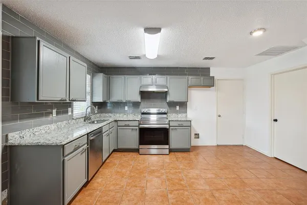 a large kitchen with a stove and a sink