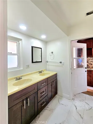 a bathroom with a granite countertop sink a toilet and a mirror