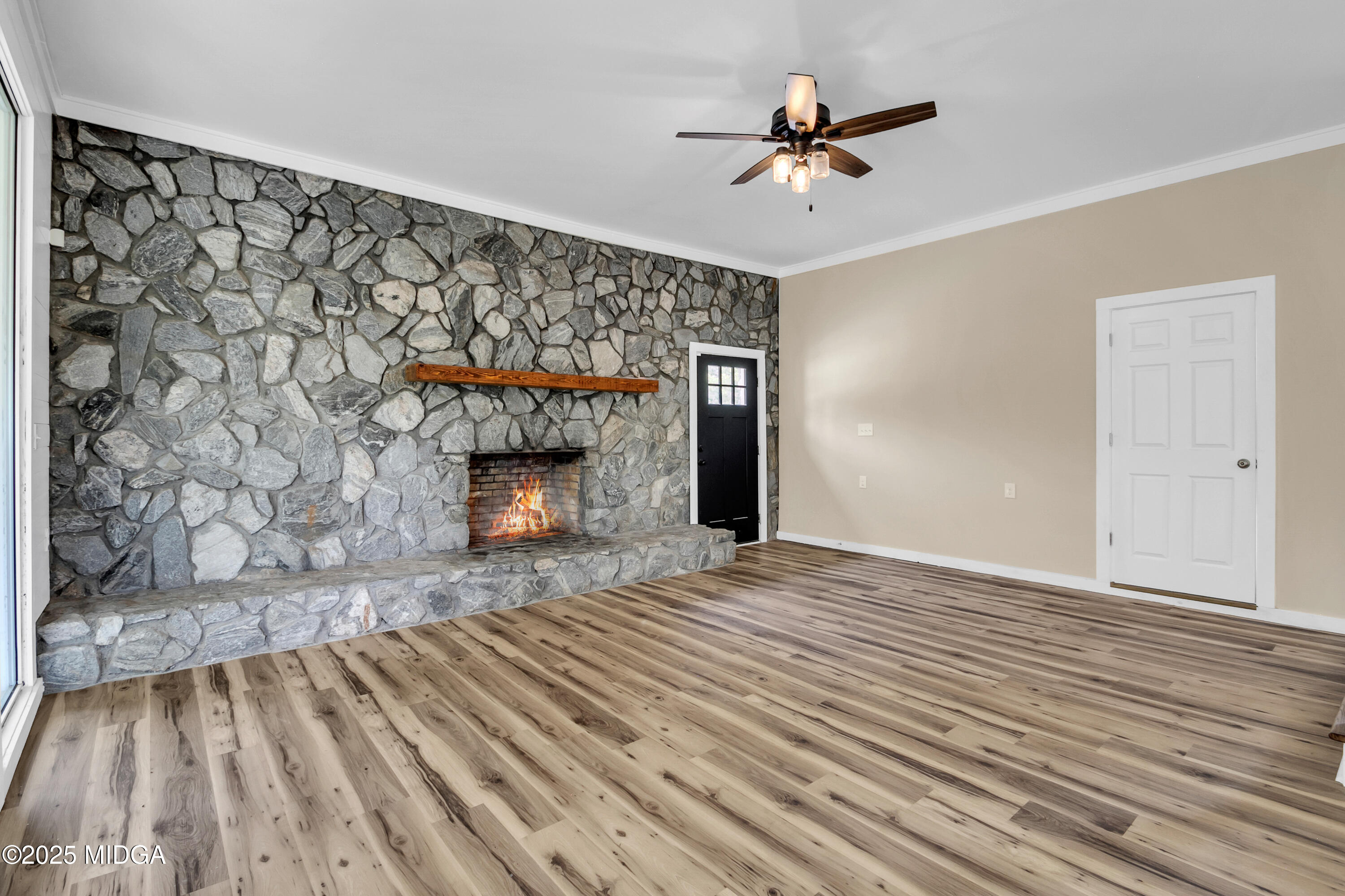 8738 Highway 87 Juliette, GA 31046 - Photo 24 of 36 a view of a livingroom with a fireplace a ceiling fan and wooden floor