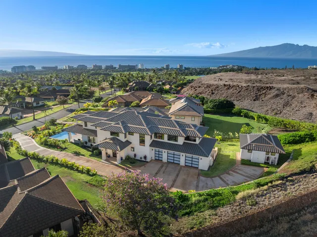 an aerial view of a house with a yard and lake view