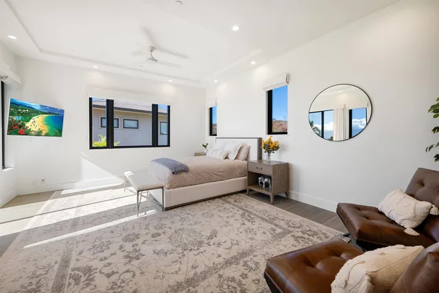 a spacious bedroom with a bed a couch and a potted plant