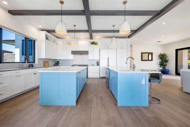 a large kitchen with cabinets wooden floor and stainless steel appliances