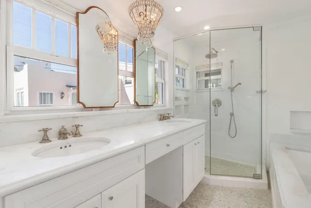 a bathroom with a double vanity sink mirror and shower