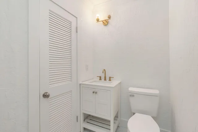 a bathroom with a toilet a sink and mirror