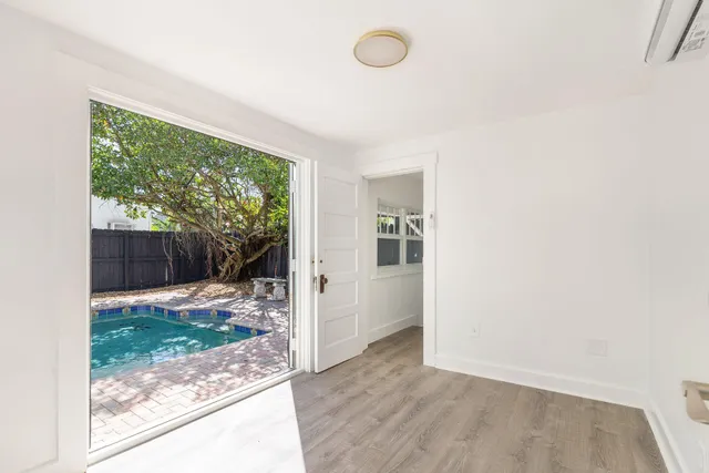 an empty room with wooden floor and entrance