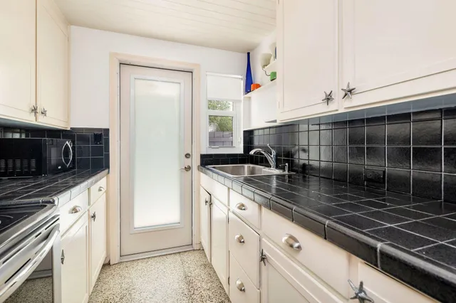 a kitchen with stainless steel appliances a sink stove and cabinets