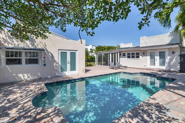 a view of a house with pool and sitting area