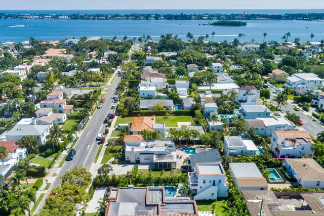 an aerial view of a city with lots of residential buildings ocean and mountain view in back