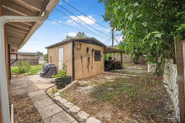 a view of a house with backyard and a tree