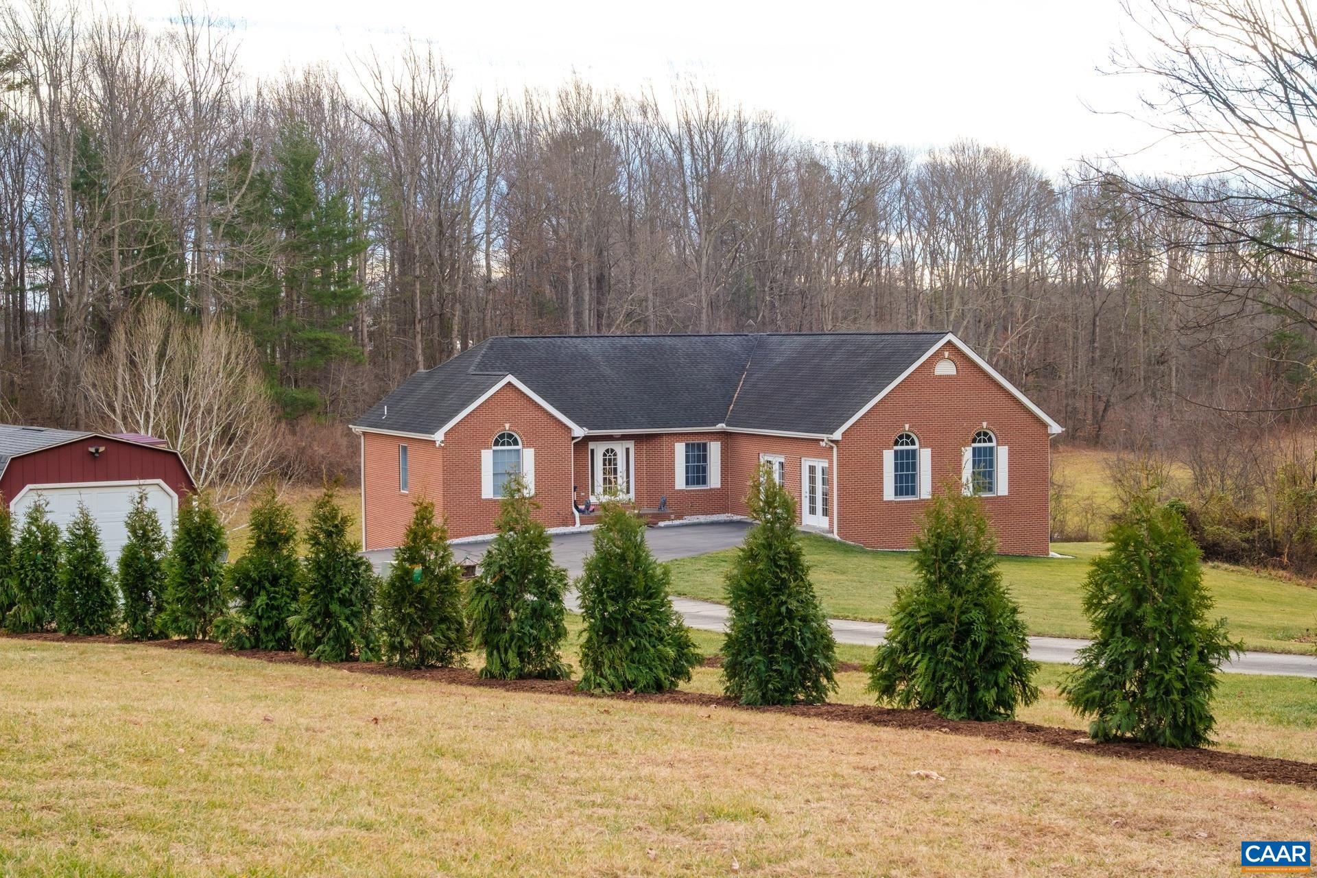 a front view of a house with a yard and trees