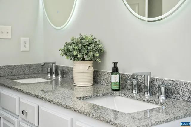 a bathroom with a granite countertop sink toilet and mirror