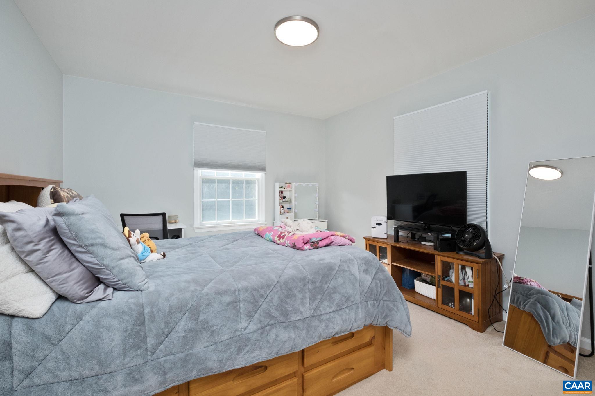 105 Squirrel Path Stanardsville, VA 22973 - Photo 43 of 67 a bedroom with bed and a flat tv screen on a dresser