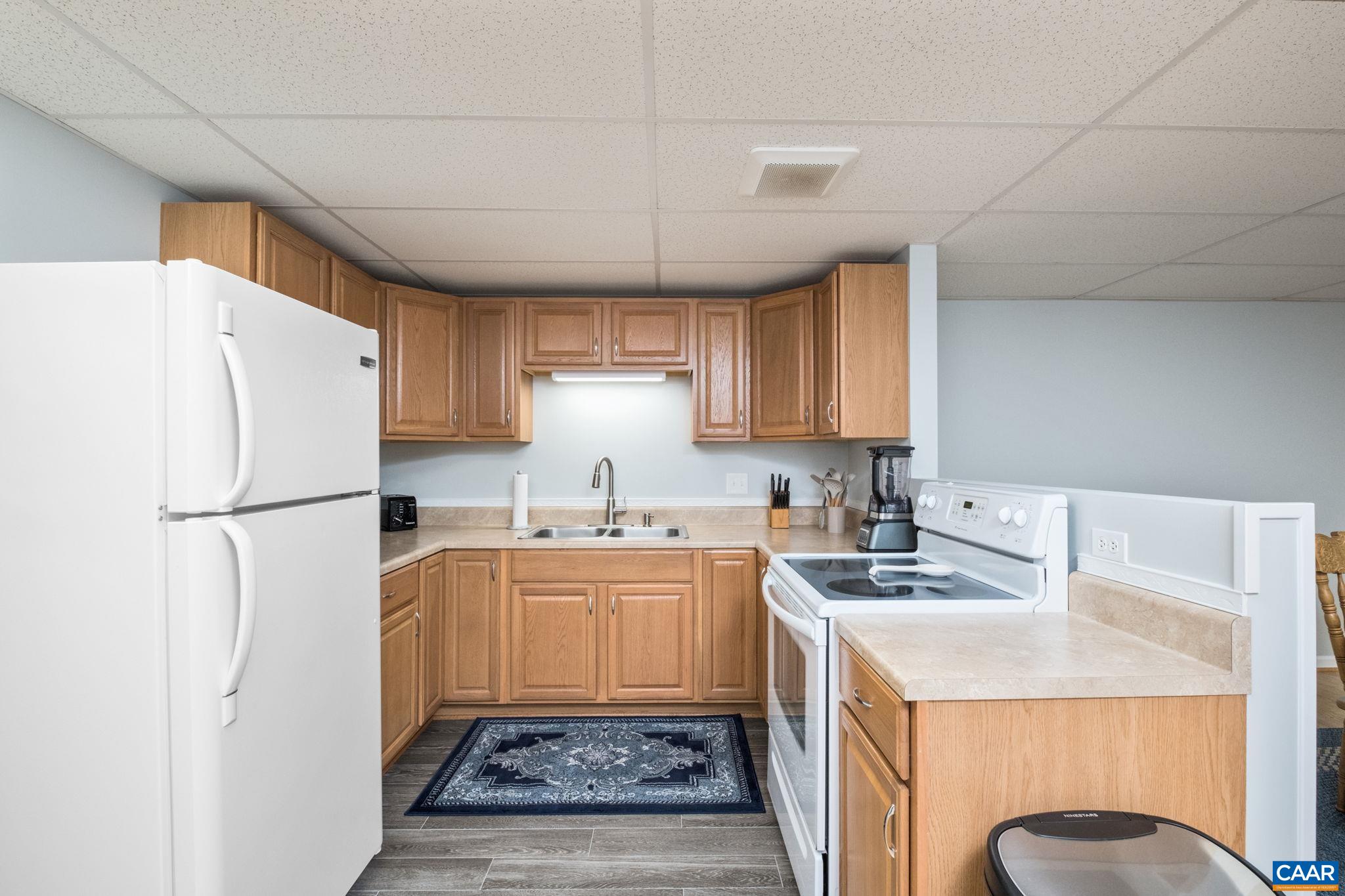 105 Squirrel Path Stanardsville, VA 22973 - Photo 47 of 67 a kitchen with a sink a refrigerator a microwave and cabinets