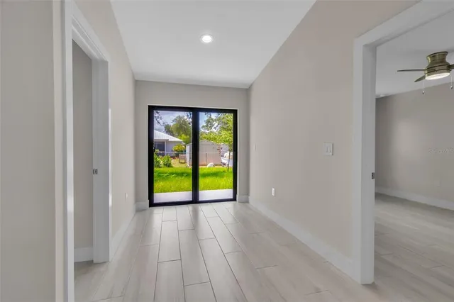a view of an empty room with window and wooden floor