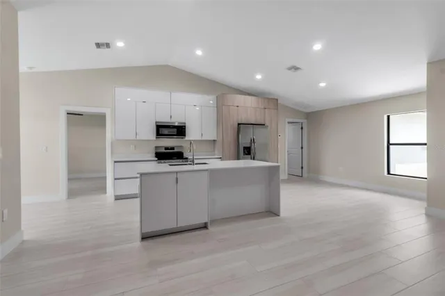 a kitchen with stainless steel appliances granite countertop a stove a sink and a refrigerator