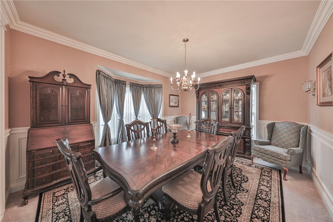 138 Clover Hollow Road Easton, PA 18045 - Photo 14 of 95 Ornate crown molding and chair rail accents highlight this refined dining area, perfect for formal gatherings.