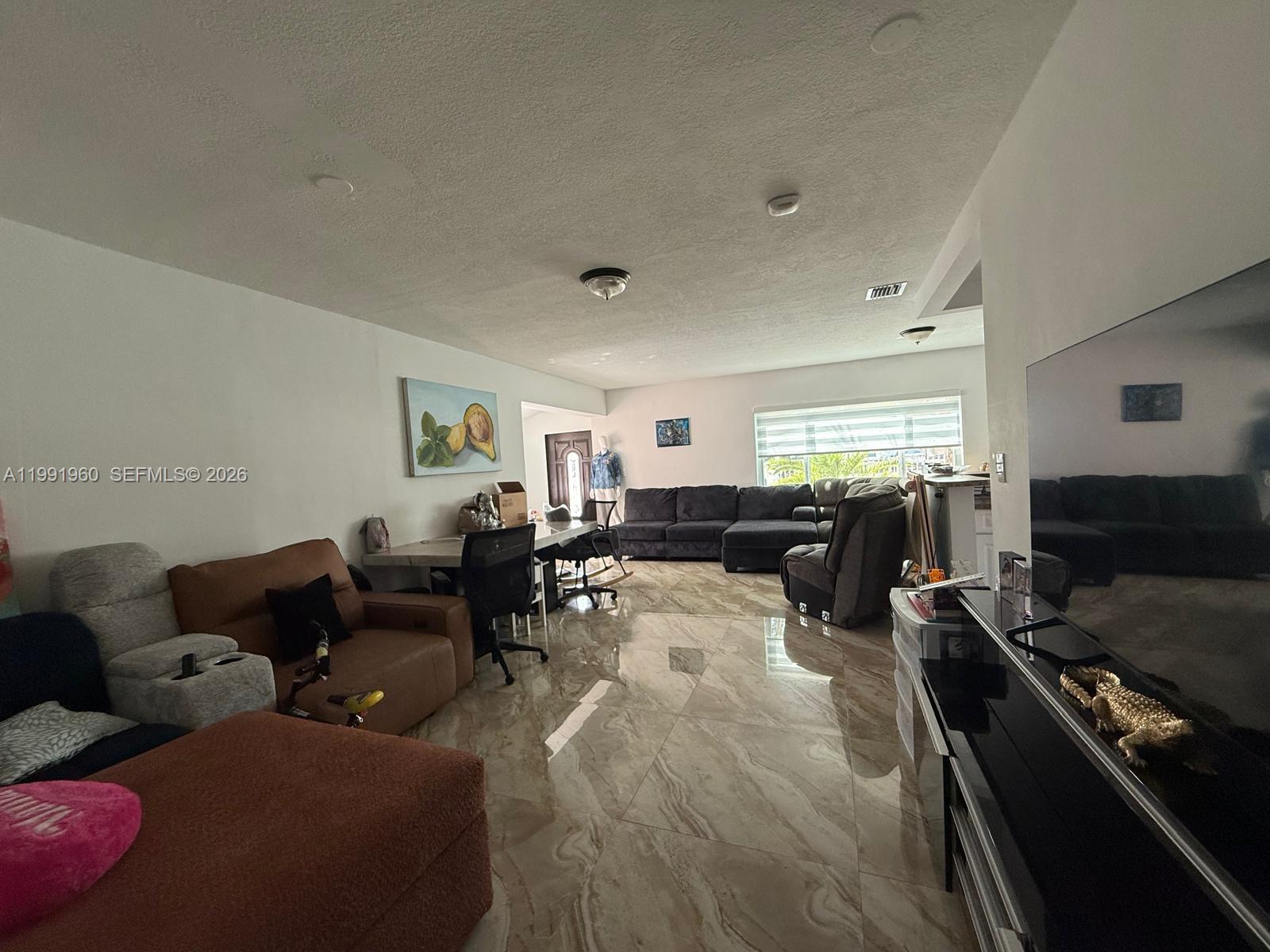 625 East 8th Lane Hialeah, FL 33010 - Photo 15 of 46 a living room with furniture and a flat screen tv
