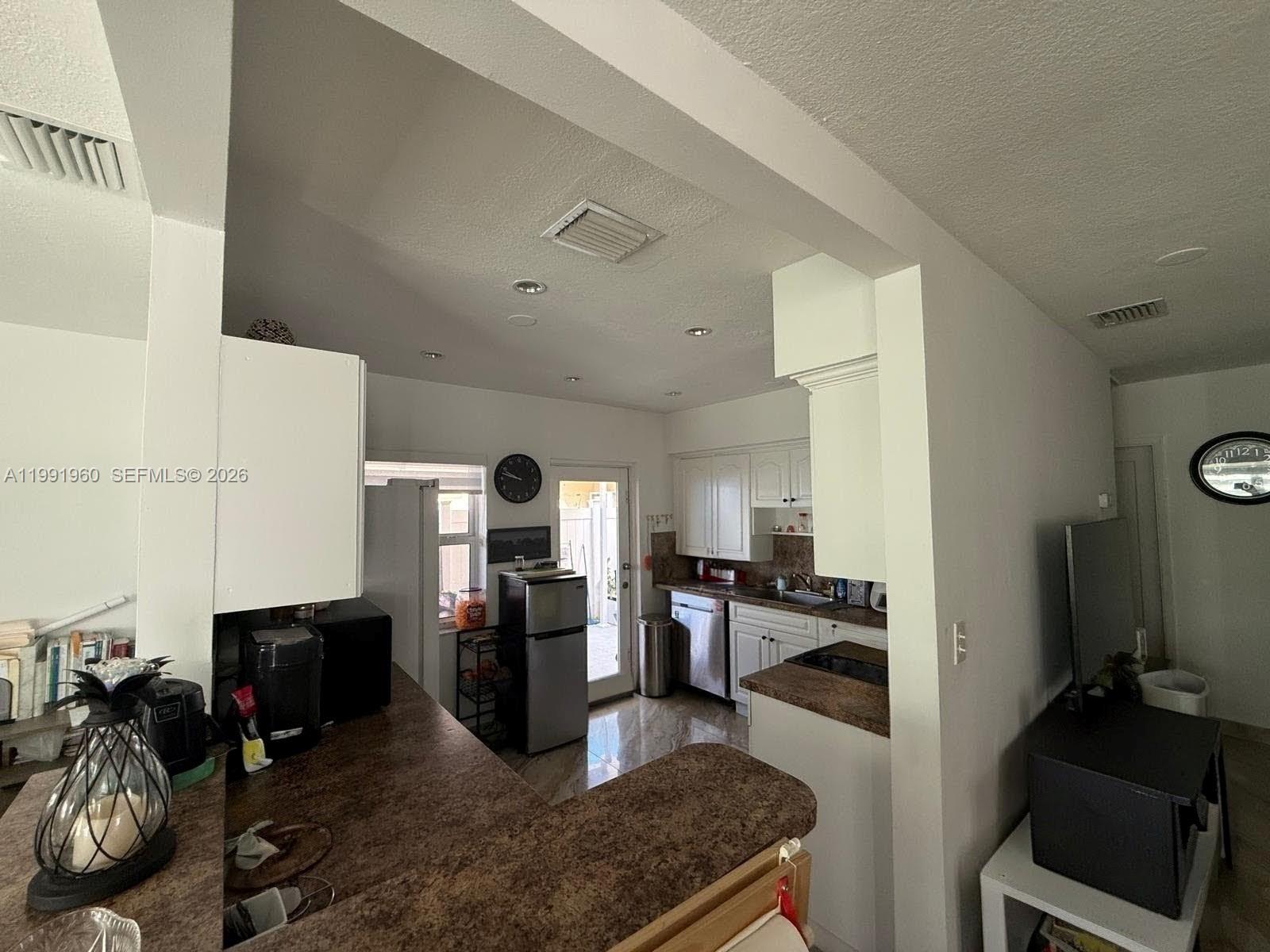625 East 8th Lane Hialeah, FL 33010 - Photo 18 of 46 a living room with stainless steel appliances furniture a rug and a view of kitchen