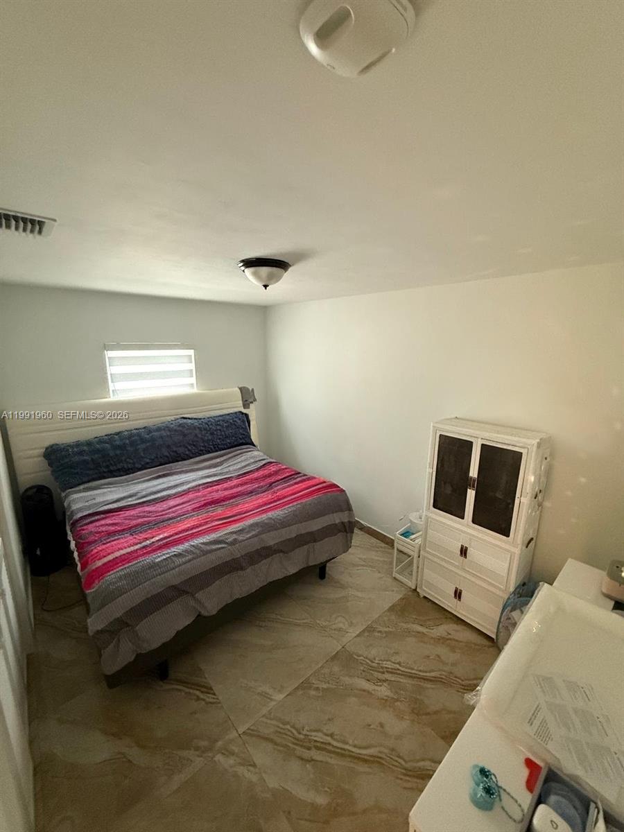625 East 8th Lane Hialeah, FL 33010 - Photo 21 of 46 a bedroom with a bed and wooden floor