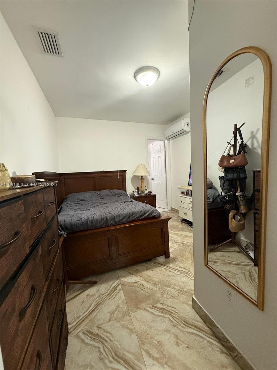 625 East 8th Lane Hialeah, FL 33010 - Photo 31 of 46 a spacious bedroom with a bed and dresser with mirror