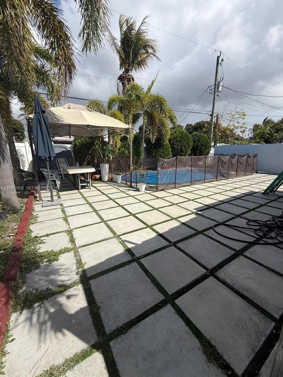 625 East 8th Lane Hialeah, FL 33010 - Photo 37 of 46 a view of a patio with table and chairs with wooden floor