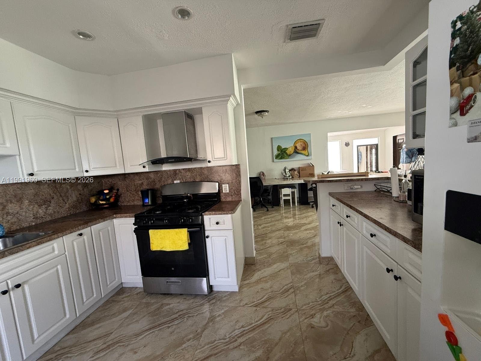 625 East 8th Lane Hialeah, FL 33010 - Photo 43 of 46 a kitchen with stainless steel appliances granite countertop a stove a sink and a microwave