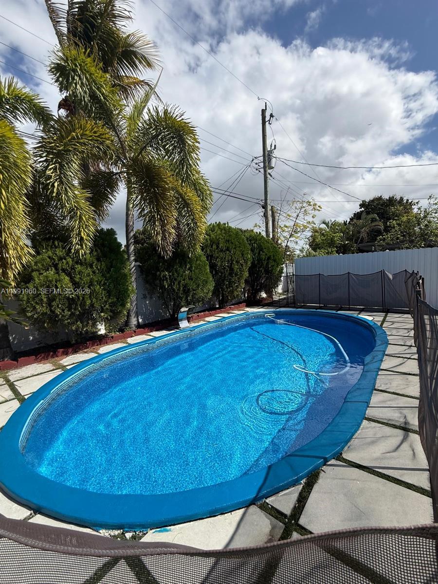 625 East 8th Lane Hialeah, FL 33010 - Photo 44 of 46 a view of a swimming pool with a lounge chair and grass