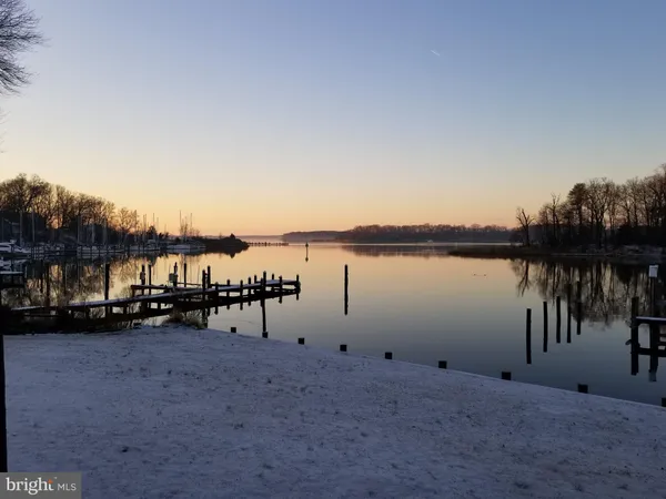 an empty room with wooden floor and a hallway
