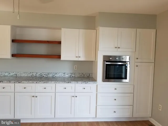 a kitchen with granite countertop white cabinets and white appliances