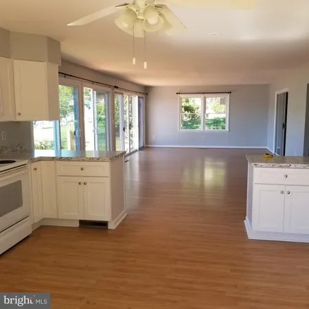 a kitchen with granite countertop white cabinets and a stove