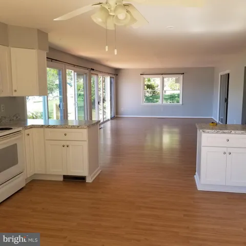a kitchen with granite countertop white cabinets and a stove