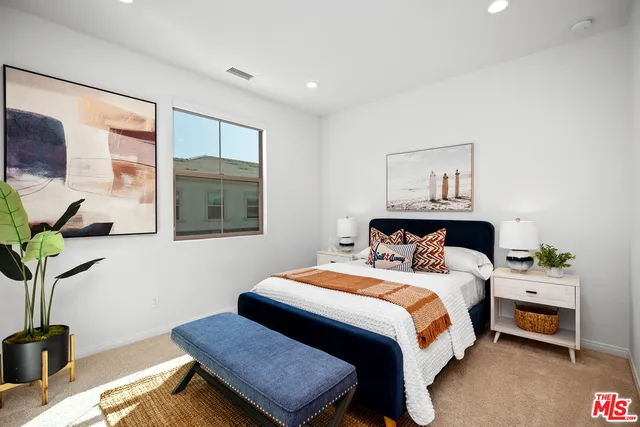 a bedroom with a bed and a potted plant