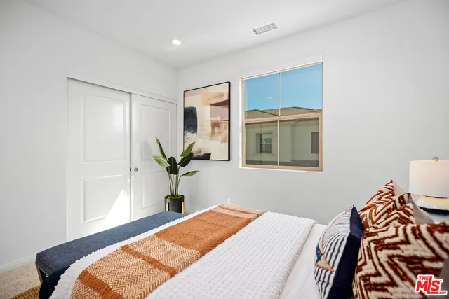 a bedroom with a bed and a potted plant