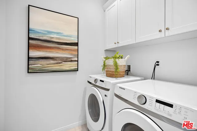 a view of washer and dryer with kitchen in the background