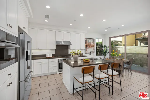 a kitchen with stainless steel appliances kitchen island granite countertop a sink and cabinets