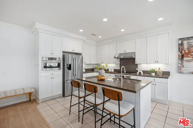 a kitchen with refrigerator cabinets and chairs