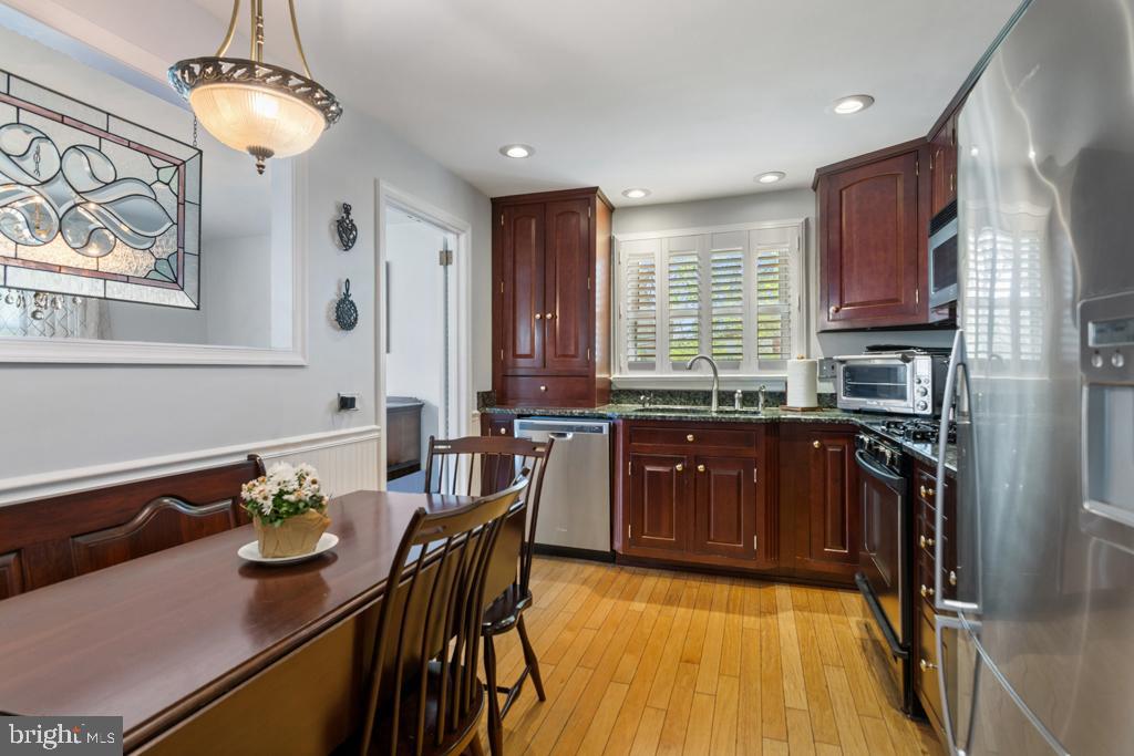 128 Locust Avenue Springfield, PA 19064 - Photo 7 of 21 a kitchen with granite countertop stainless steel appliances stove a dining table and chairs