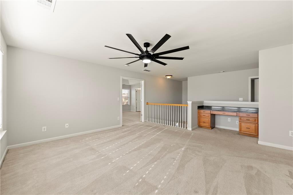 3181 Day Break Lane Dacula, GA 30019 - Photo 12 of 25 a view of a livingroom with a ceiling fan and kitchen space