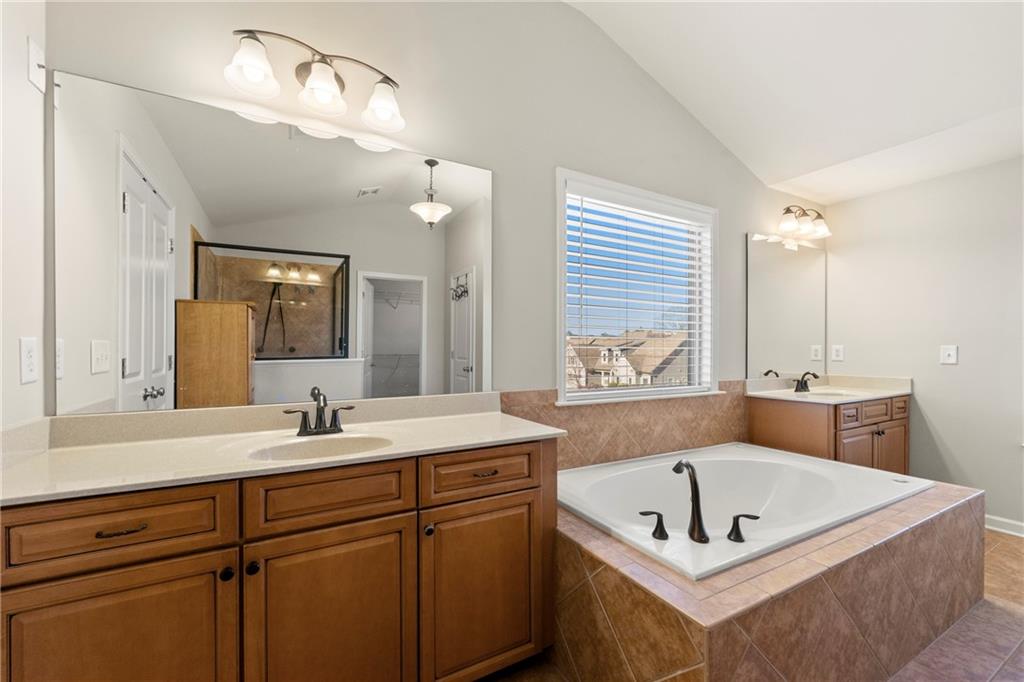 3181 Day Break Lane Dacula, GA 30019 - Photo 20 of 25 a bath room with a sink a mirror and a bathtub