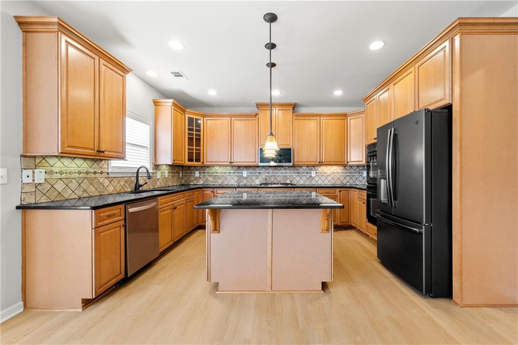 3181 Day Break Lane Dacula, GA 30019 - Photo 3 of 25 a kitchen with stainless steel appliances granite countertop a refrigerator a sink a stove a microwave and island