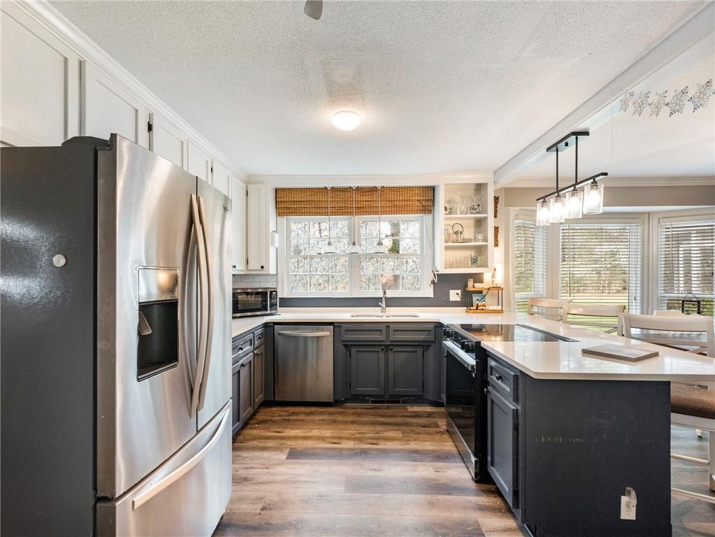 945 Poplar Street Monroe, GA 30655 - Photo 18 of 55 a kitchen with stainless steel appliances granite countertop a refrigerator and a sink
