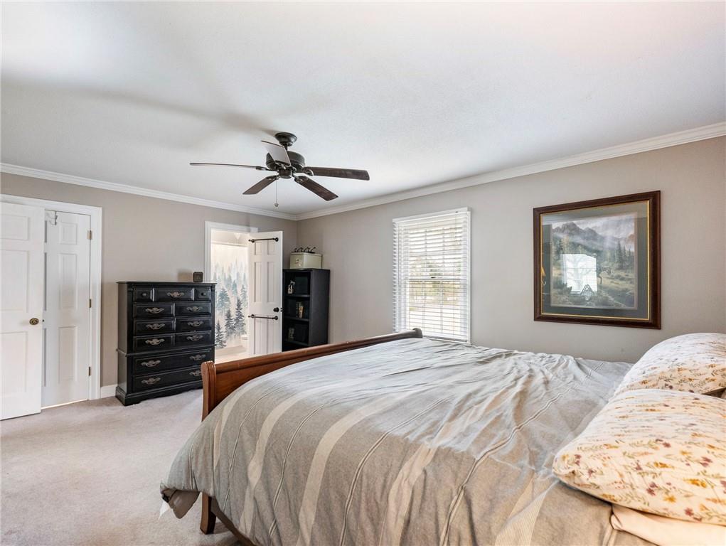 945 Poplar Street Monroe, GA 30655 - Photo 40 of 55 a spacious bedroom with a bed a dresser and a large mirror