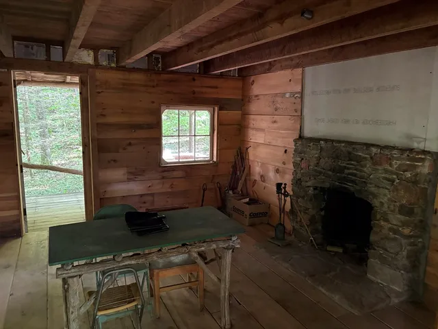 a living room with a fireplace wooden floor and a table